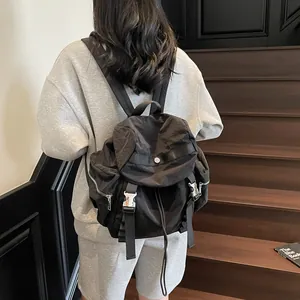 Lightweight black nylon backpack with multi-pocket design and metallic buckles for travel