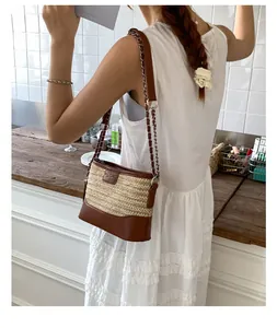 Close-up of woven straw texture and premium brown leather trim on a hobo bucket bag