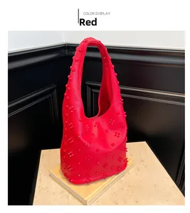 Detail view of red hobo bag with pebble leather texture and tonal stud decorations