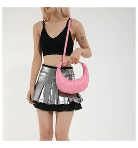 Vue détaillée du sac croissant rose avec poignée en métal et texture cuir élégante