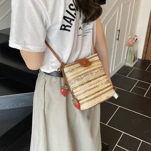 Handmade woven bucket bag with brown leather flap and red strawberry charms for summer