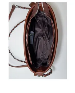 Close-up of the spacious brown bucket bag interior with smooth fabric lining and logo label
