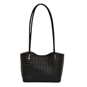 Bolso tote de cuero negro con patrones geométricos calados por láser y correas de hombro