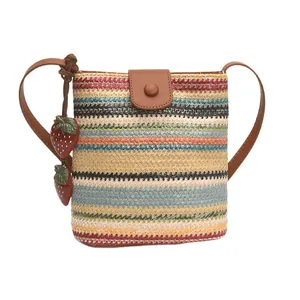 Handwoven straw bucket bag with colorful stripes, leather strap, and strawberry charms