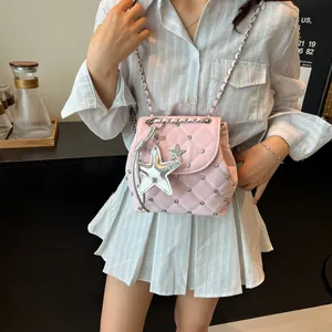 Quilted pink crossbody bag with silver star charms and chain strap shown on a model