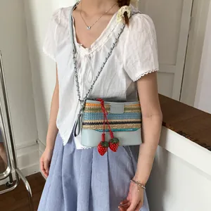 Rainbow striped straw bucket bag with blue leather trim and red strawberry charms