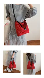 Detail of red hollow knit shoulder bag with mesh weave and black strap for summer