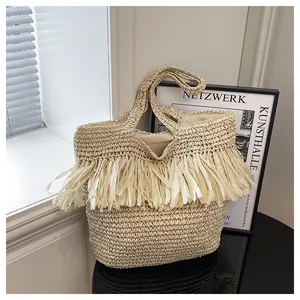 Detail van beige rieten shopper met bohemien franjes en zachte stoffen binnenvoering