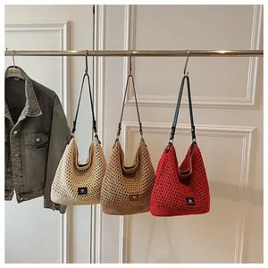 Detail of hollow knit shoulder bags in cream, khaki, and red with rustic woven texture