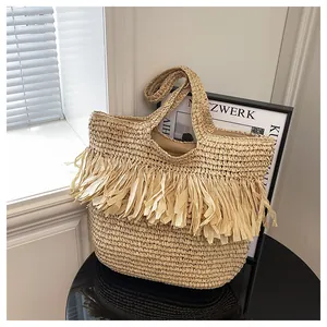 Detail van bohemian rieten tas met lange franjes en natuurlijke geweven textuur