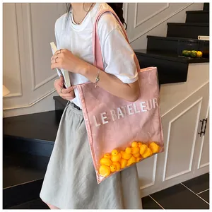 Vue détaillée du sac cabas rose avec couche transparente remplie de canards jaunes
