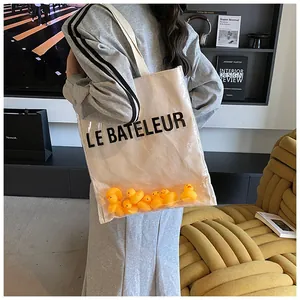 Détail du sac cabas transparent en PVC avec petits canards jaunes et toile interne