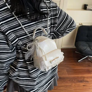 Chic cream mini bucket backpack with lace trim and elegant pearl chain accessory