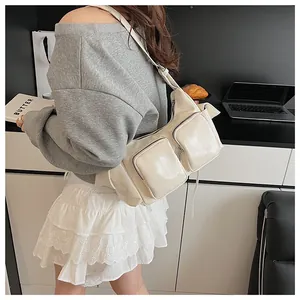 Detailed side view of multi-pocket shoulder bag with glossy cream finish and zippers