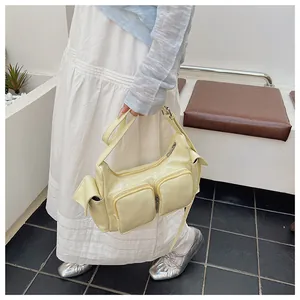 Detail view of cream-colored shoulder bag featuring functional multi-pockets and leather texture