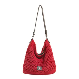 Red knit hobo bag with hollow texture and adjustable leather strap for summer vacation