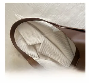 Close-up of dark brown leather tote bag handle showing high-quality stitching detail
