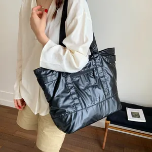 Large capacity black quilted nylon tote bag with embroidery shown on model