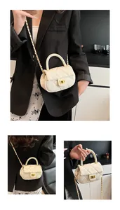 Detail of quilted leather crossbody bag featuring gold chain strap and metal turn-lock