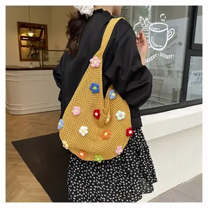 Detail of yellow hand-crocheted tote bag with colorful 3D floral knit decorations