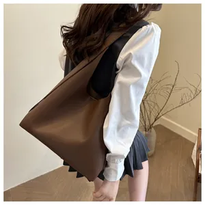 Deep brown oversized tote bag with integrated wide strap showing slouchy drape effect