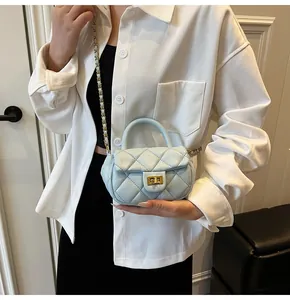 Detail shot of light blue quilted mini bag with gold twist lock and woven chain strap
