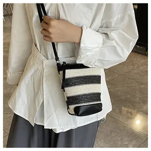 Detail view of striped bucket bag with knit texture and black leather trim on model
