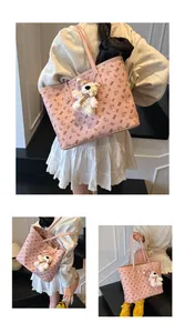 Detail view of pink tote bag featuring cute bear prints and a plush bear charm accessory