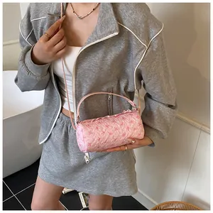 Borsa a cilindro rosa con motivi a fiocco e tessuto a bolle testurizzato indossata da modella