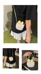Detail of cream mini crossbody bag featuring yellow bow embroidery and lace ruffle edges