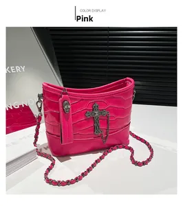 Detail of pink crocodile texture shoulder bag with metal cross and skull studs decoration