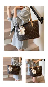 Close-up of brown tote bag featuring teddy bear prints and a plush bear charm detail