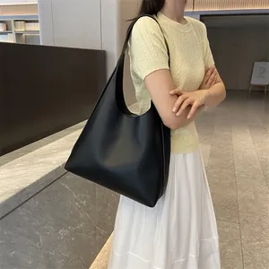 Minimalist black leather tote bag with a spacious triangular design for daily commuting