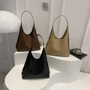 Minimalist large leather tote bags in black, brown and beige on geometric stands