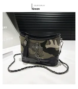 Macro detail of gothic camo shoulder bag featuring metal cross and skull charm