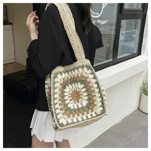 Close-up of handmade crochet tote bag with green and beige floral granny square patterns