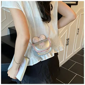Close-up of pink mini crossbody bag with lace trim and bow embroidery on model