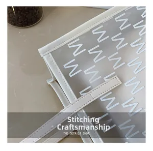 Close-up of precise stitching process on the ivory jelly tote bag handle and PVC body