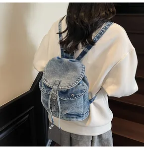 Detalle de mochila denim vintage con cierre de cordón y hebilla metálica al dorso