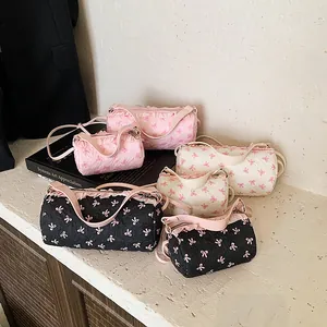 Borse a secchiello cilindriche trapuntate con stampe fiocco rosa in rosa, bianco e nero