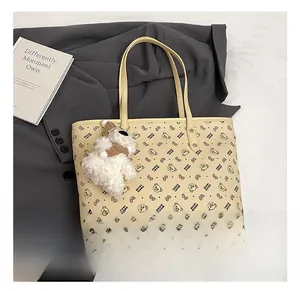 Detail of beige tote bag featuring bear prints and a cute plush bear charm accessory
