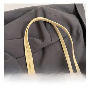 Detail showing high-quality stitching on PU leather handles of a beige tote bag