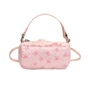Borsa a cilindro rosa con motivi a fiocco e raffinati dettagli di balze plissettate