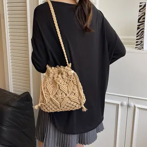 Beige crochet bucket bag with hollow woven pattern shown from a back view on a model