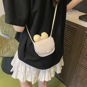 Mini cream crossbody bag for kids with lace bow and ruffles shown on a model