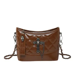 Brown quilted leather hobo bag with vintage metal cross and skull charm detail