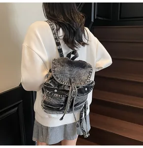 Vista trasera de una modelo con la mochila vintage de mezclilla con doble bolsillo