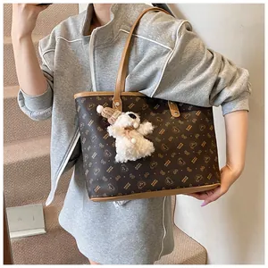 Detail of bear print tote bag with brown plush bear charm and premium stitching finish