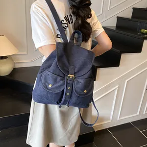 Large denim backpack for women featuring two front pockets and flap closure design