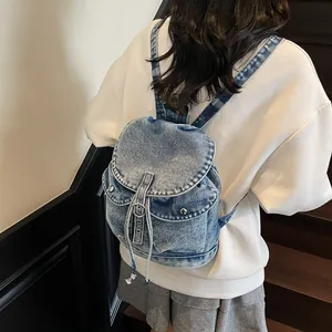 Mochila de mezclilla azul claro vintage con múltiples bolsillos y cordón para viaje diario